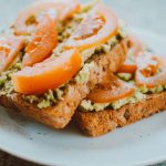Delicious homemade sandwich with tomato, avocado on wholegrain bread, perfect for a healthy meal.